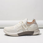 Damen-Sneaker in Beige mit gestricktem Obermaterial, elastischer Sohle und Schnürsenkeln. Bequeme Freizeitschuhe für Alltag und Sport.