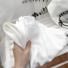Weiße Bluse aus Baumwolle, elegant gefaltet, ideal für Business- und Freizeitkleidung. Perfekt für stilvolle, moderne Outfits.