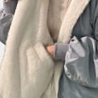 Damen-Winterjacke mit weichem, weißem Kunstfellfutter und grauer Außenschicht. Stilvoll, warm und perfekt für kalte Wintertage.