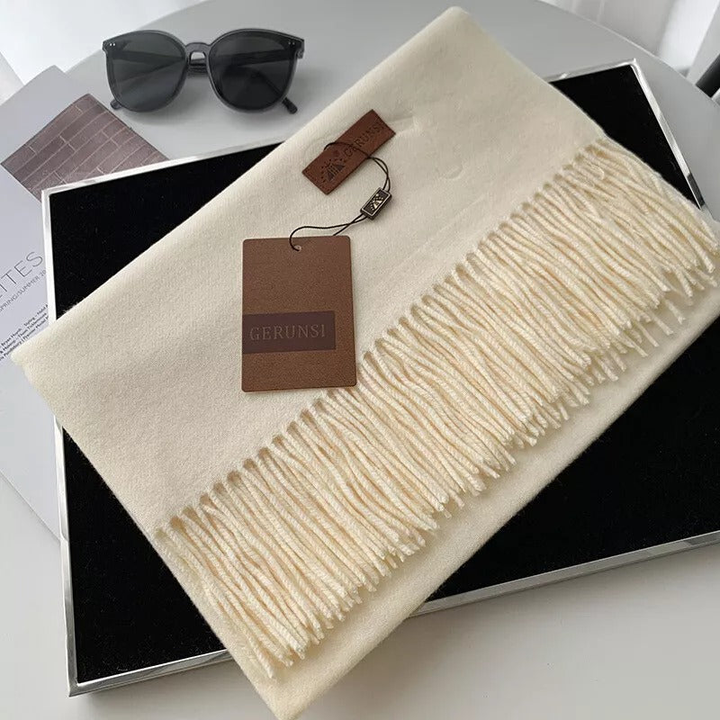 Luxuriöser cremeweißer Schal aus Kaschmir mit Fransen, stilvoll präsentiert in einer Geschenkbox. Perfekt für elegante Wintermode und Accessoires.