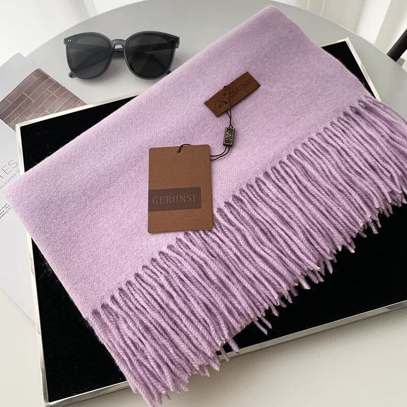 Luxuriöser lila Schal aus Kaschmir mit Fransen, stilvoll präsentiert auf schwarzem Hintergrund. Perfekt für elegante Mode und Accessoires.