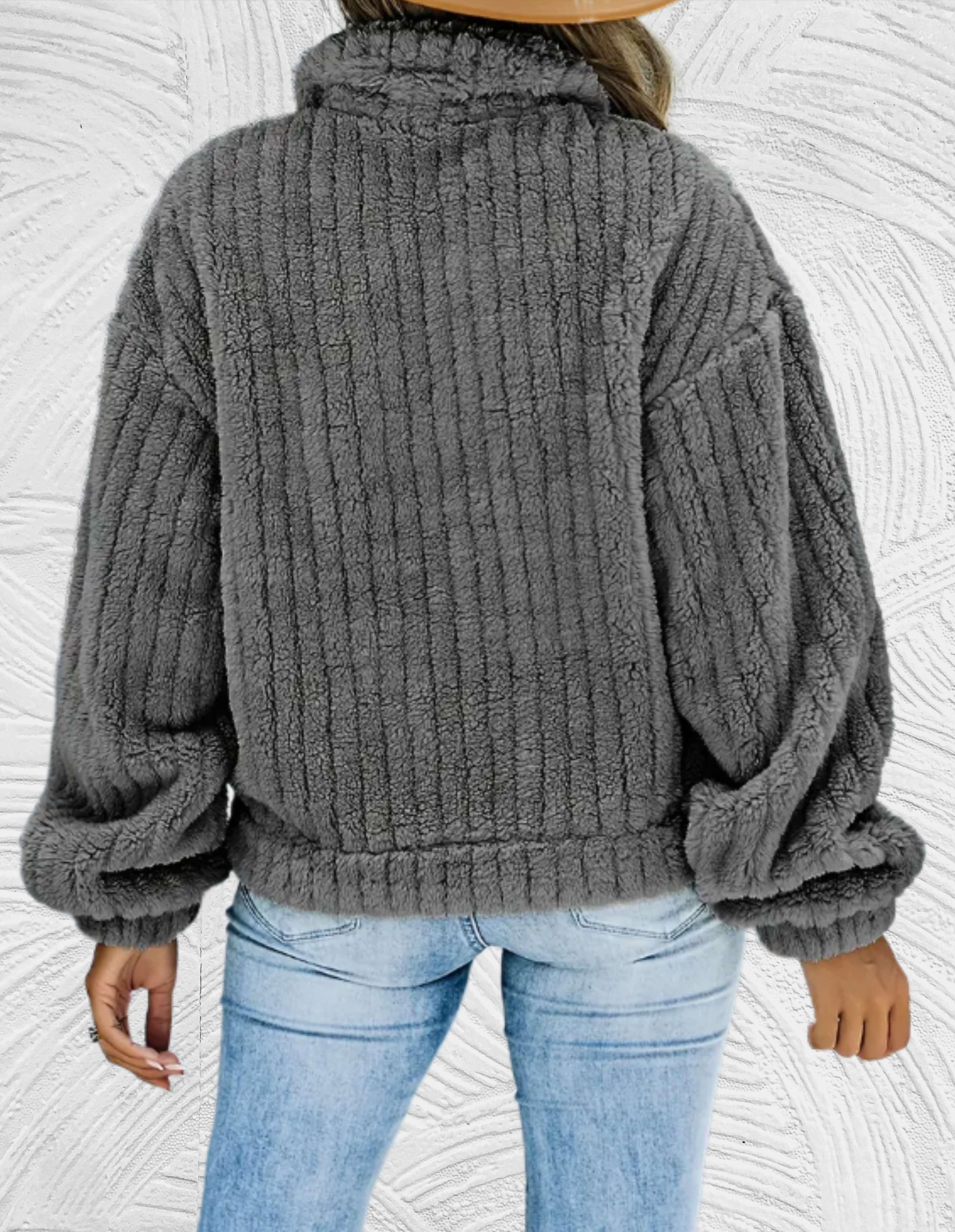 Grauer, plüschiger Damenpullover mit geripptem Design, ideal für Herbstmode. Bequeme, warme Oberbekleidung, perfekt für kühle Tage.