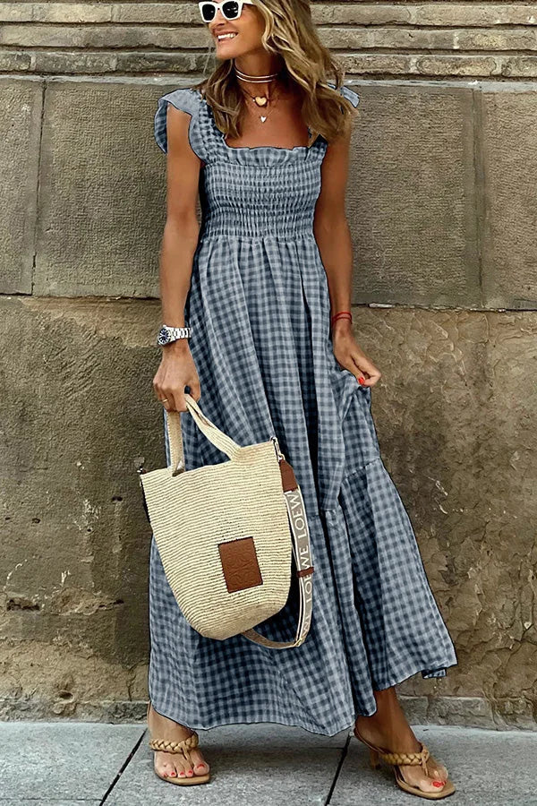 Frau in kariertem Maxikleid mit Strohtasche, Sonnenbrille und Sandalen. Sommermode, lässiger Stil, trendiges Outfit für Damen.