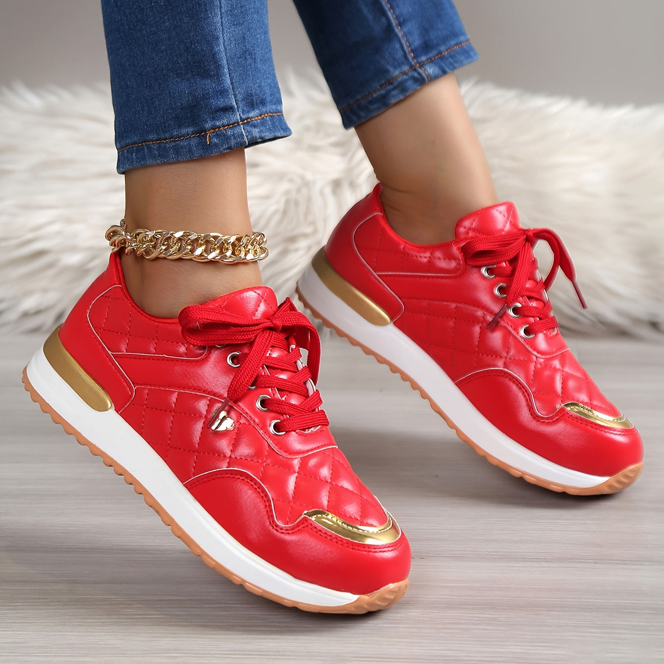 Rote Damen-Sneaker mit goldenen Akzenten, gestepptem Design und weißer Sohle. Modische Sportschuhe, ideal für Freizeit und Streetwear.