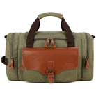 Grüne Canvas-Reisetasche mit braunen Lederakzenten, robust und stilvoll für Reisen.