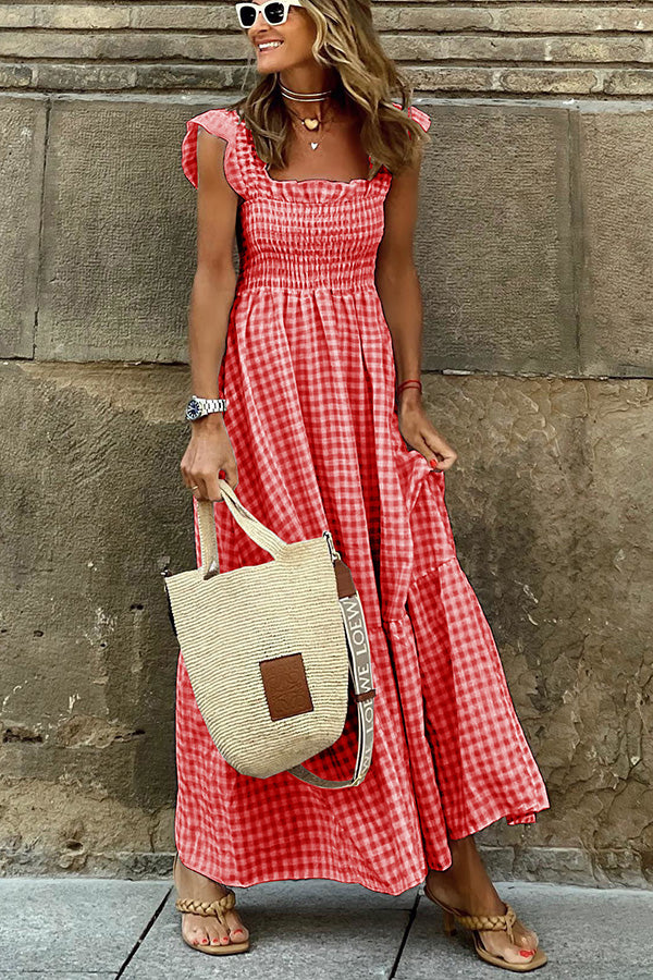 Frau in rotem, kariertem Sommerkleid mit Strohtasche und Sonnenbrille. Perfekt für Strandmode, Sommeroutfits und Freizeitkleidung.