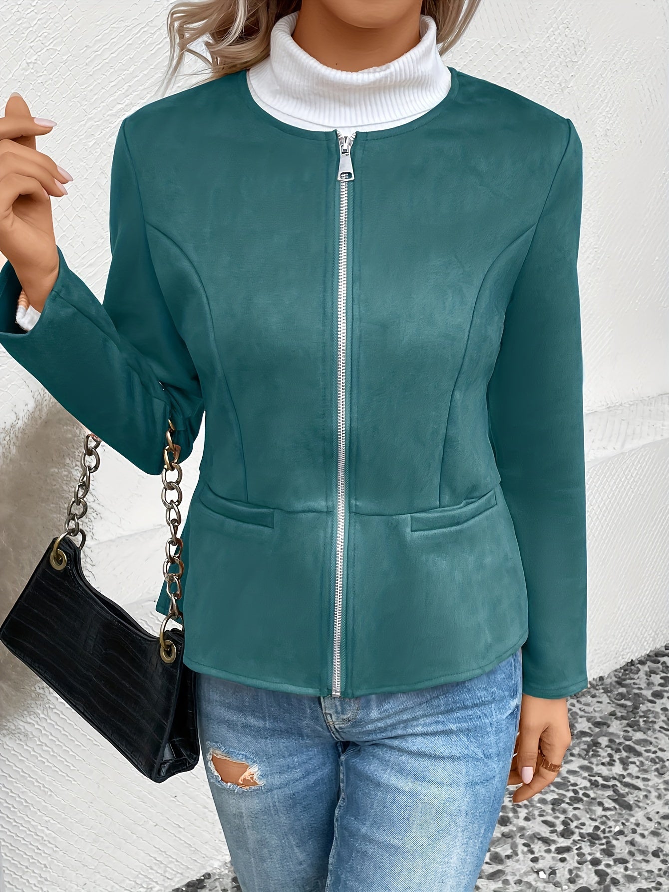 Damenjacke in Türkis mit Reißverschluss, kombiniert mit Jeans und schwarzer Handtasche. Modetrend, stilvolle Oberbekleidung, Herbstmode.