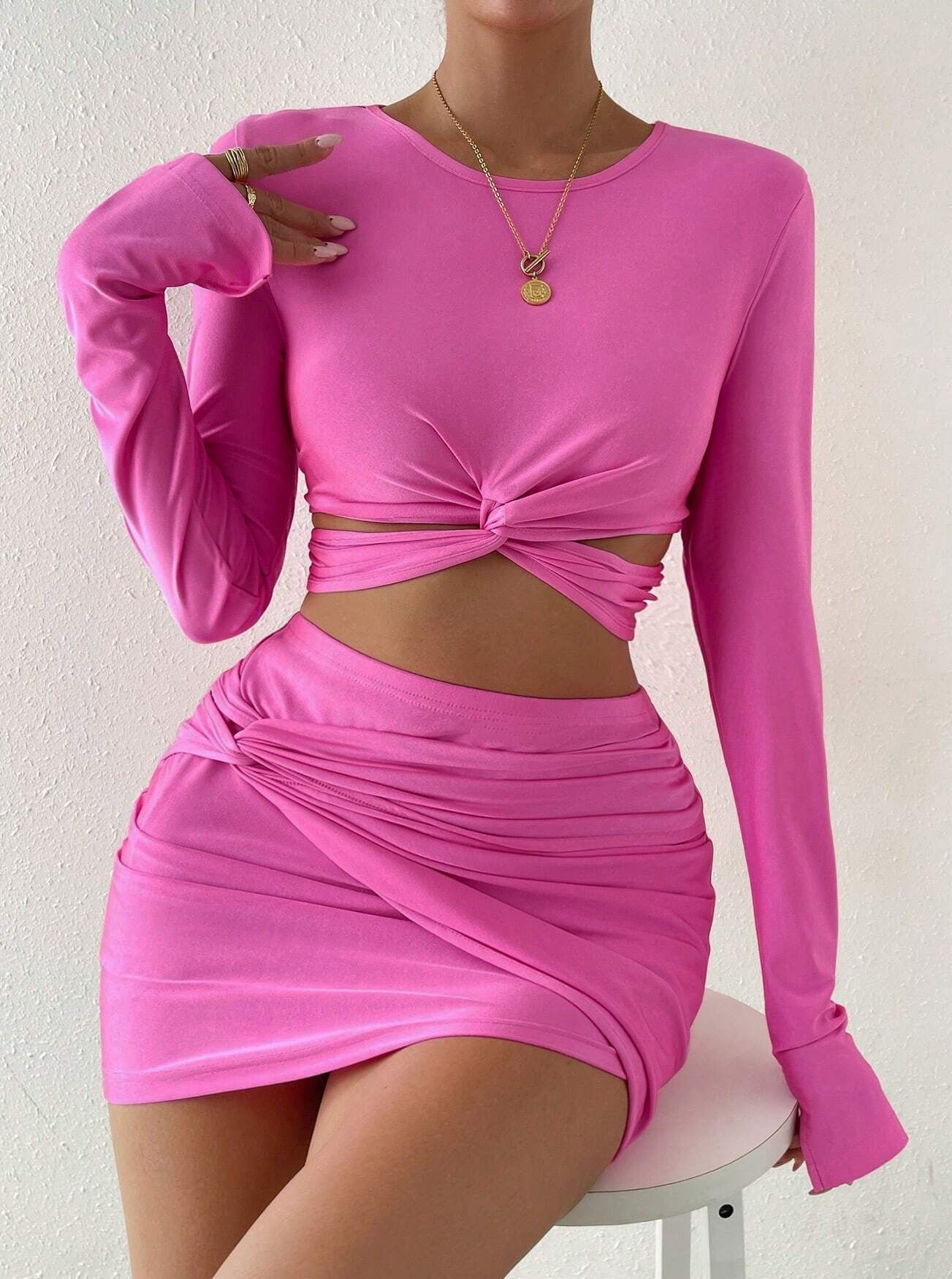 Damenmode: Pinkes, langärmeliges Crop-Top und Minirock-Set mit Knoten-Detail. Trendiges Outfit, ideal für Partys und Sommermode.