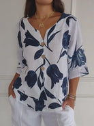 Damenbluse mit V-Ausschnitt, florales Muster, Knopfleiste, 3/4-Ärmel, lässig, weiß-blau, ideal für Sommermode und Freizeitoutfits.