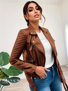 Frau in brauner Lederjacke, weißem Pullover und blauer Jeans. Modetrend, stilvolle Damenbekleidung, elegante Freizeitmode.