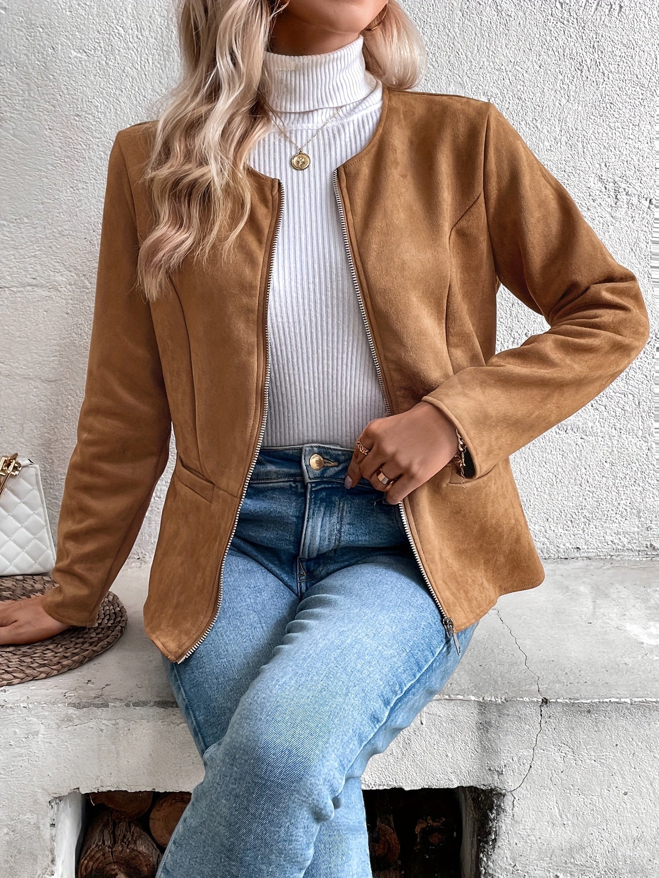 Damenmode: Elegante braune Wildlederjacke, kombiniert mit weißem Rollkragenpullover und blauer Jeans. Perfekt für stilvolle Herbst-Looks.