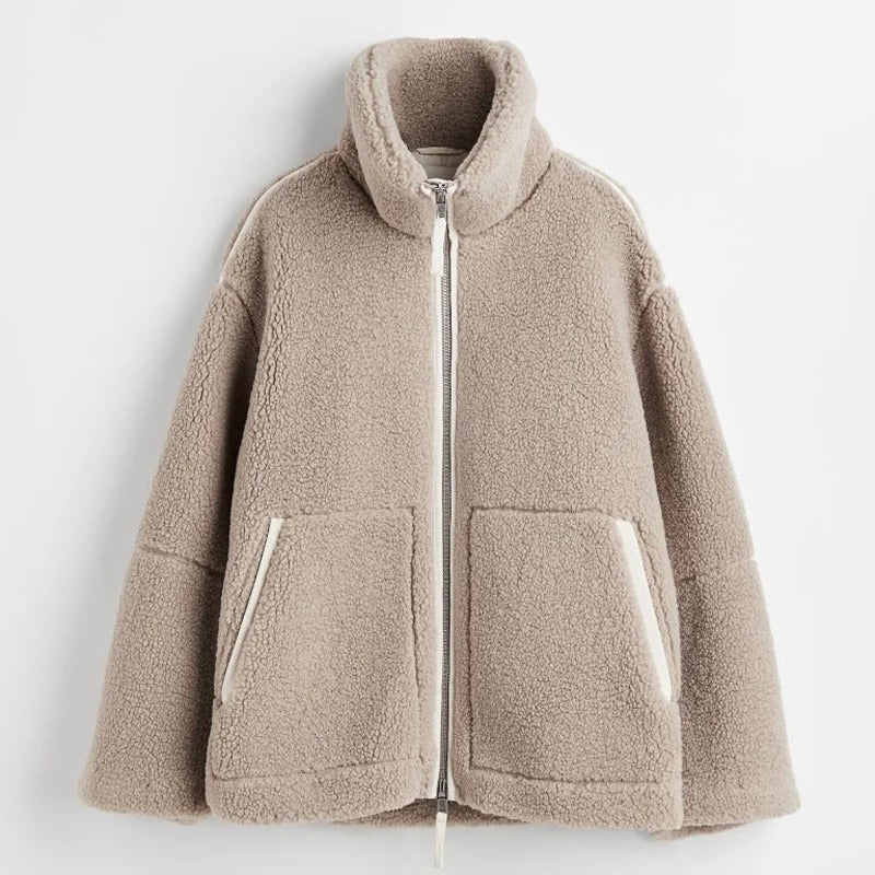 Beige Teddyjacke mit Reißverschluss, kuscheligem Fleece, Stehkragen und Taschen. Perfekt für Herbstmode und Wintertrends.