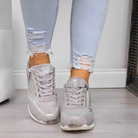 Graue Sneaker mit Glitzer-Details, kombiniert mit zerrissenen Jeans. Modische Damen-Schuhe, ideal für trendige Freizeitlooks.