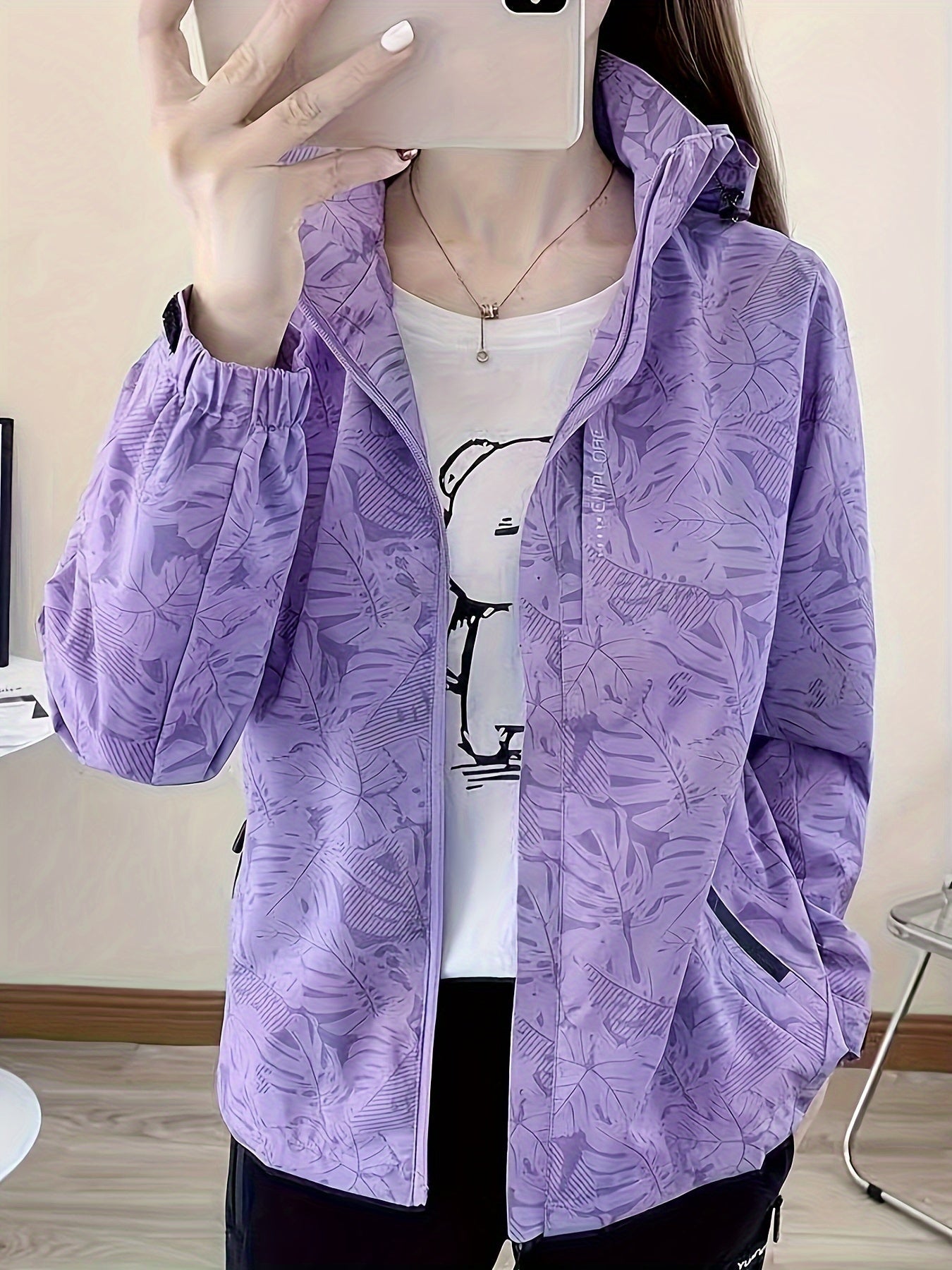 Lila Damenjacke mit floralem Muster, Reißverschluss und Stehkragen. Modische Freizeitkleidung, ideal für Frühling und Herbst.