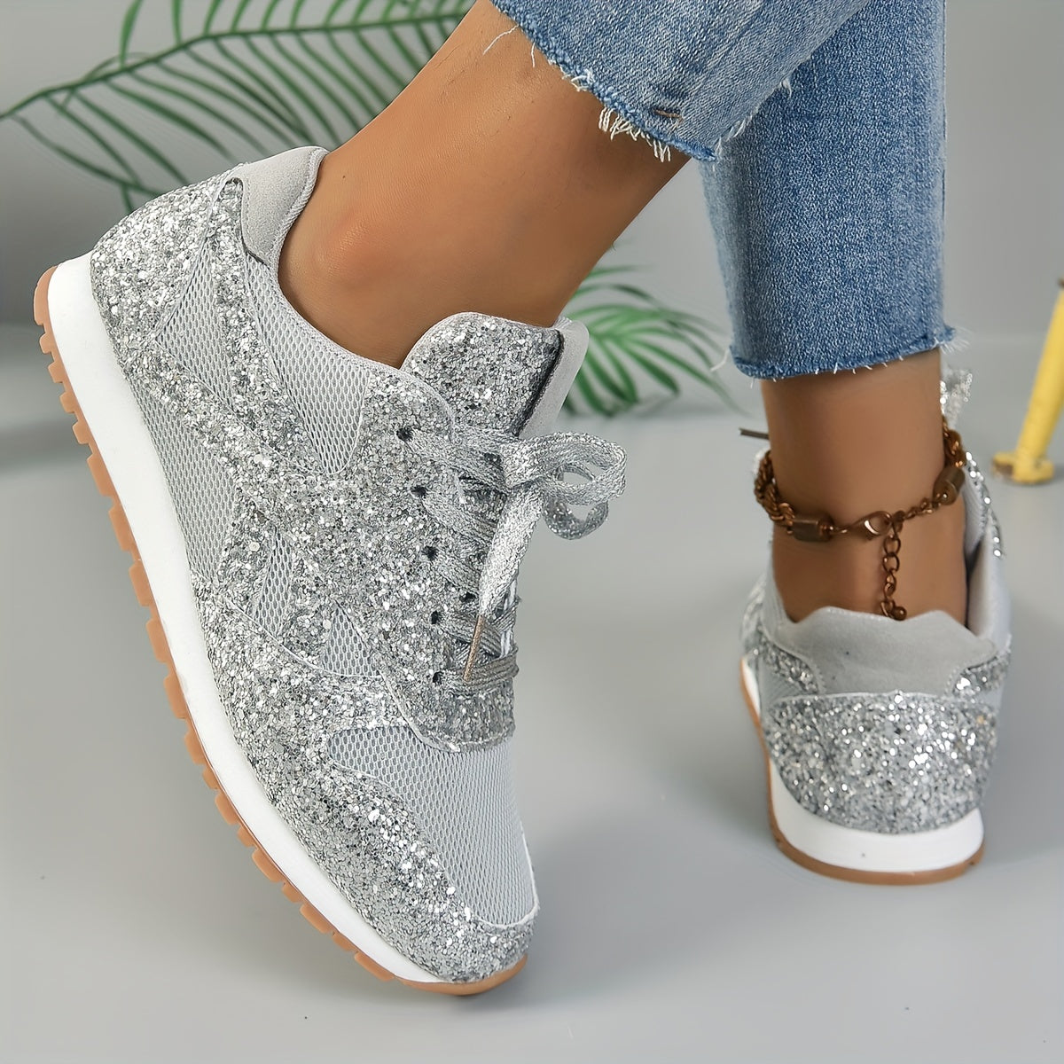 Graue Glitzer-Sneaker für Damen, kombiniert mit blauen Jeans. Modische, bequeme Schuhe, ideal für Freizeit und Streetstyle.