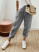 Gestreifte Damenhose, lässig und bequem, kombiniert mit weißem T-Shirt und Sneakers. Perfekt für Freizeitmode und Sommeroutfits.