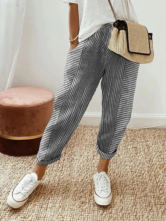 Gestreifte Damenhose, lässig und bequem, kombiniert mit weißem T-Shirt und Sneakers. Perfekt für Freizeitmode und Sommeroutfits.
