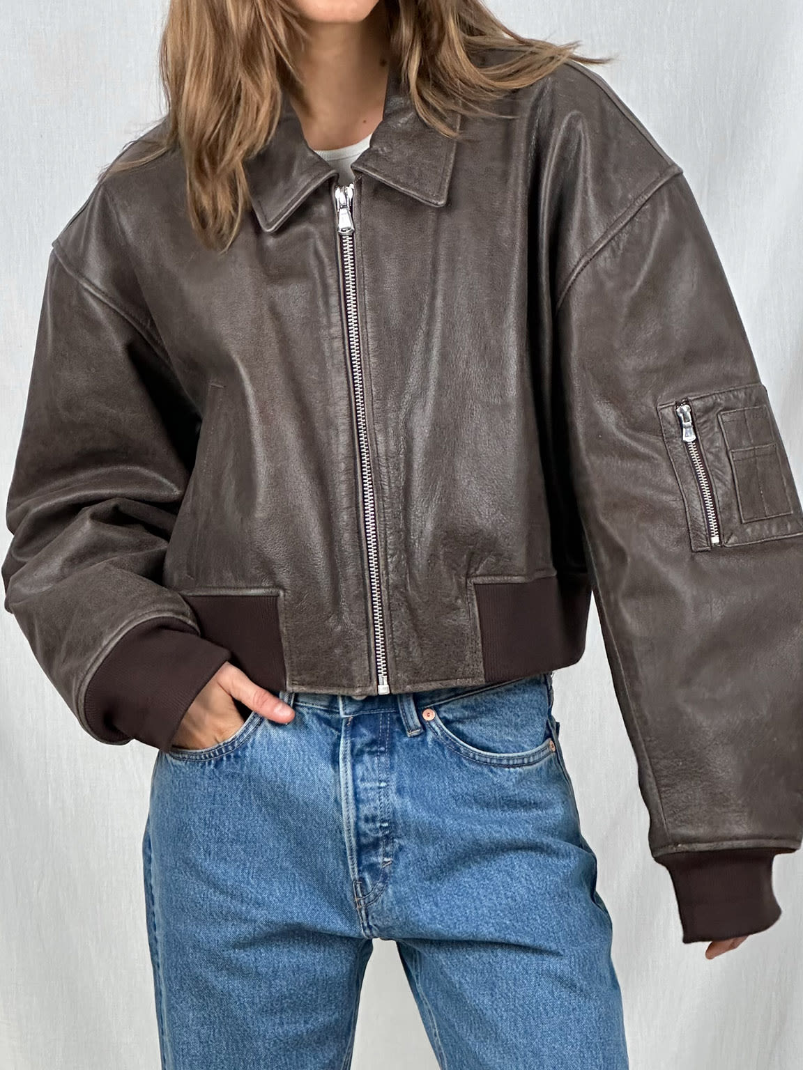 Damen-Lederjacke in Dunkelbraun mit Reißverschluss, lässigem Schnitt und gerippten Bündchen. Perfekt für modische Herbst- und Winteroutfits.