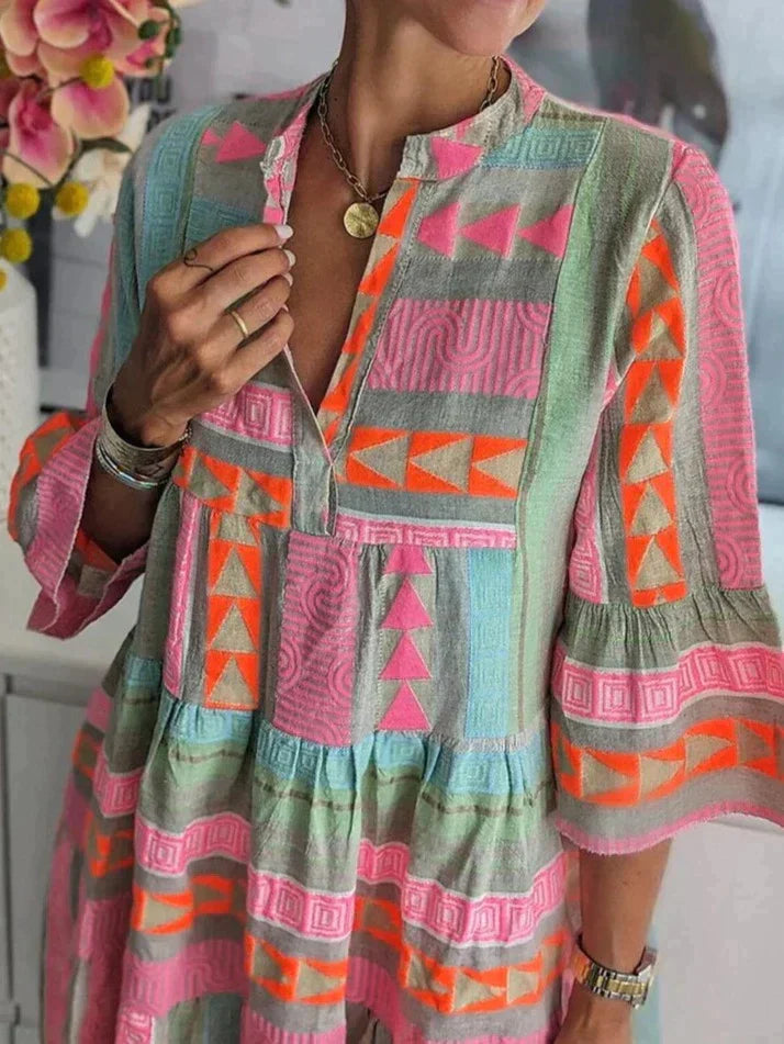 Bunte Boho-Bluse mit geometrischem Muster, leuchtenden Farben und lockerer Passform. Perfekt für Sommermode und Festival-Outfits.