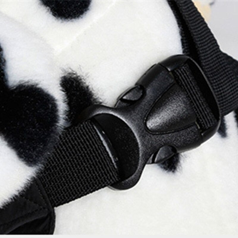 Schwarzer Kunststoffverschluss an einem schwarz-weißen Hundegeschirr. Robustes Design, ideal für Haustierkontrolle und Sicherheit.