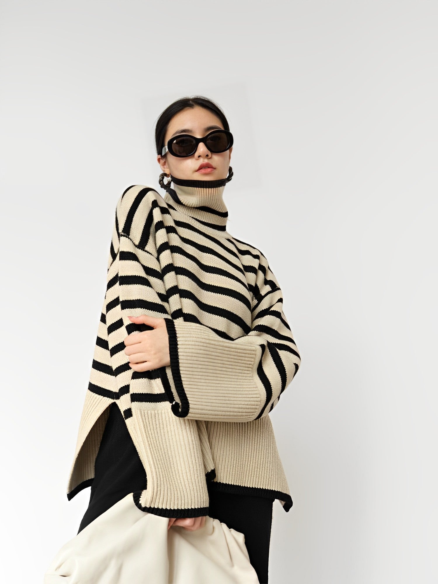 Frau in gestreiftem Rollkragenpullover, schwarze Sonnenbrille, modisch, elegant, Herbstmode, Damenbekleidung, trendiger Look, stilvoll.