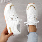Weiße Sneaker mit goldenen Akzenten, gestepptem Design und Gummisohle. Modische Damen-Sportschuhe, ideal für Freizeit und Streetwear.