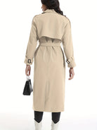 Eleganter beiger Trenchcoat für Damen, knielang, mit Gürtel und Rückenschlitz. Perfekt für stilvolle Herbst- und Wintermode.