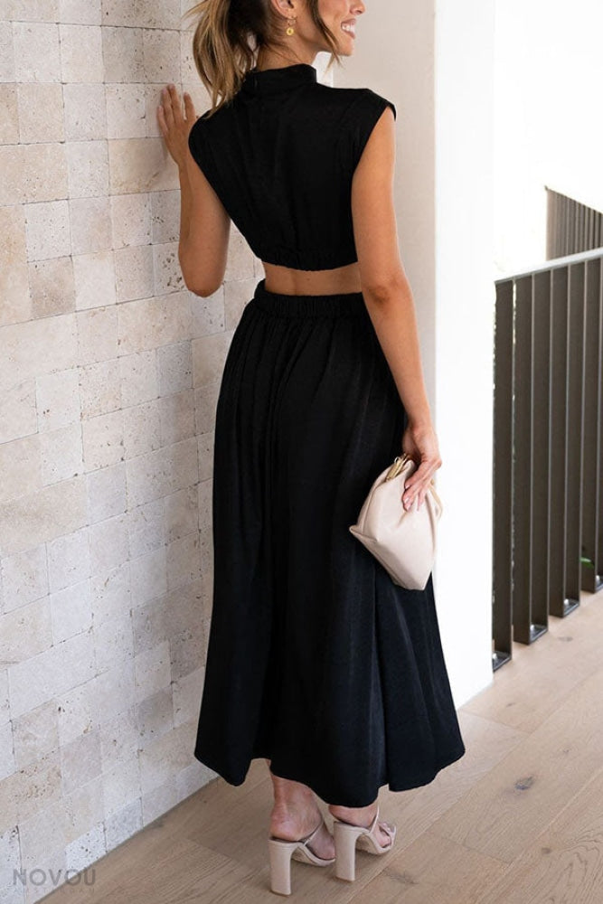 Elegantes schwarzes Maxikleid, ärmellos, mit elastischer Taille. Perfekt für Sommermode, kombiniert mit beigen High Heels und Clutch.