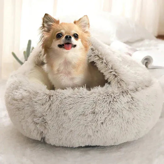 Kleiner Hund in weichem, grauem Kuschelbett für Haustiere, ideal gegen Angst und Stress.
