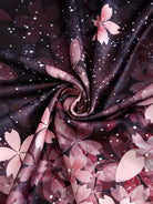 Rosa Kirschblütenmuster auf schwarzem Stoff, ideal für Frühlingsmode und Dekoration.