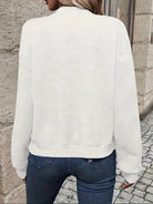 Damenpullover in Weiß mit geometrischem Muster, lässig und stilvoll. Perfekt für Herbstmode, kombiniert mit Jeans für einen eleganten Look.