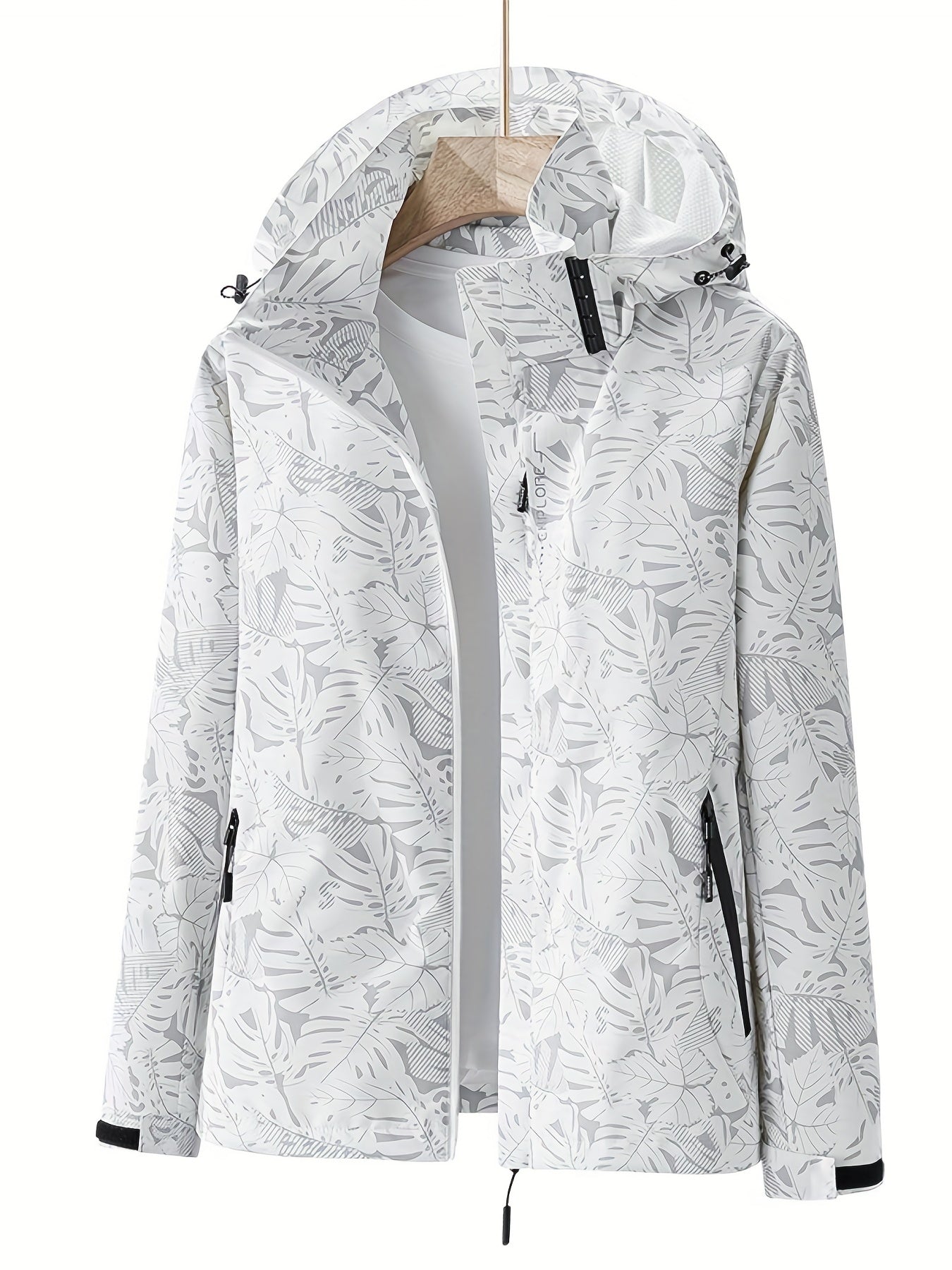 Weiße Damenjacke mit Kapuze, tropischem Blattmuster und Reißverschlusstaschen. Perfekt für Outdoor-Aktivitäten. Modisch, funktional, wasserabweisend.
