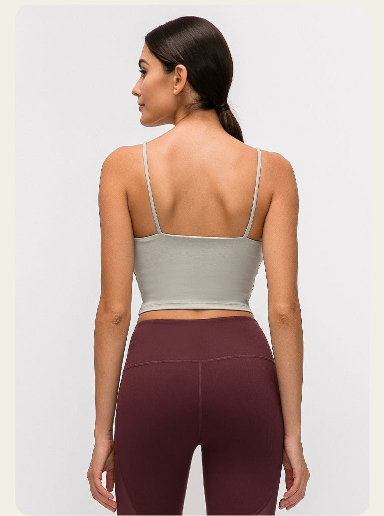 Damen-Sportbekleidung: Nahtloses, graues Crop-Top mit Spaghettiträgern und bordeauxrote Leggings. Perfekt für Yoga und Fitness.