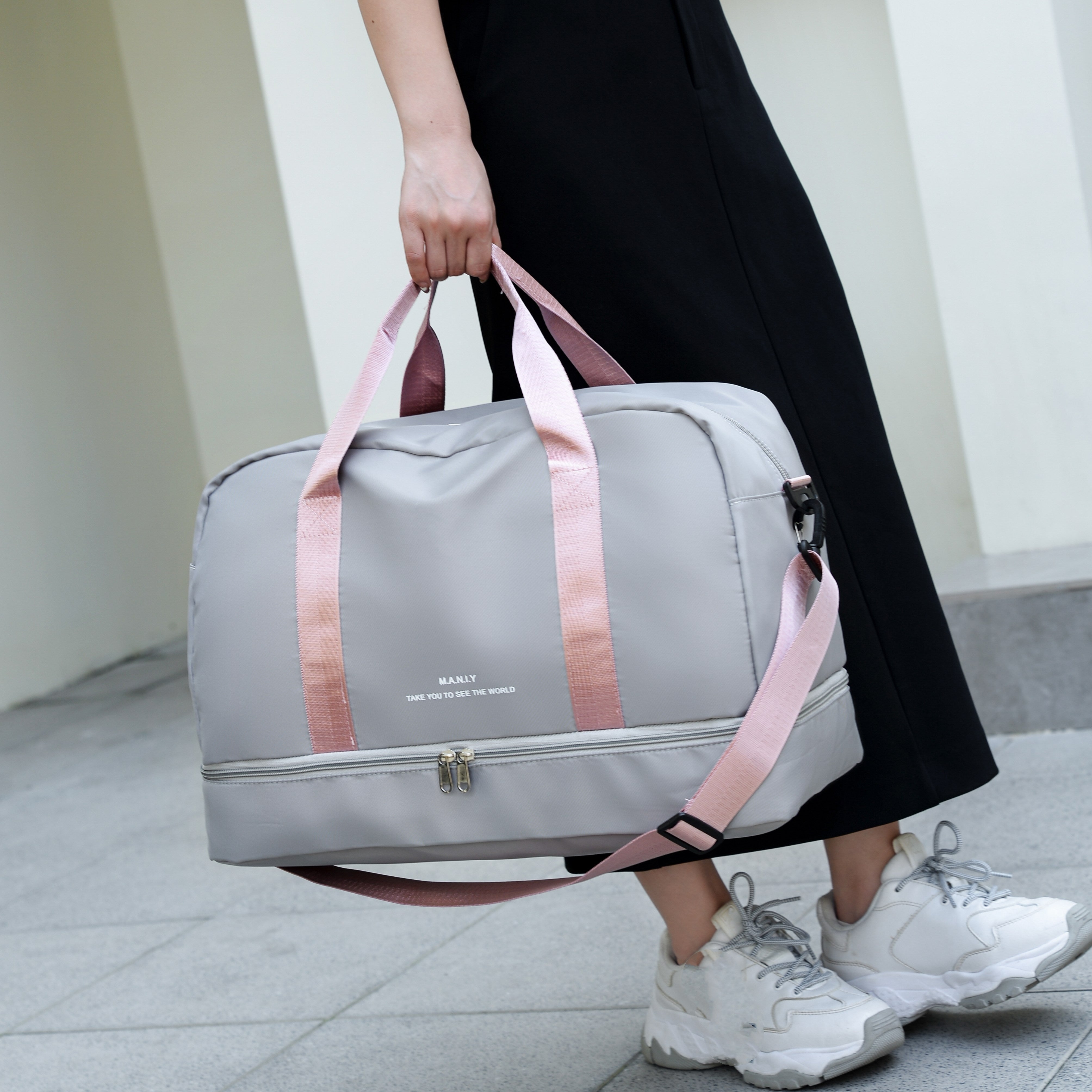 Graue Reisetasche mit rosa Trägern, ideal für Damen. Praktische Sporttasche, geräumig, stilvoll, perfekt für Reisen und Fitnessstudio.