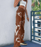 Braune Denim-Jeans mit weißem Herz-Print, modisch und trendig, ideal für Streetwear-Looks. Perfekt für stilbewusste Frauen.