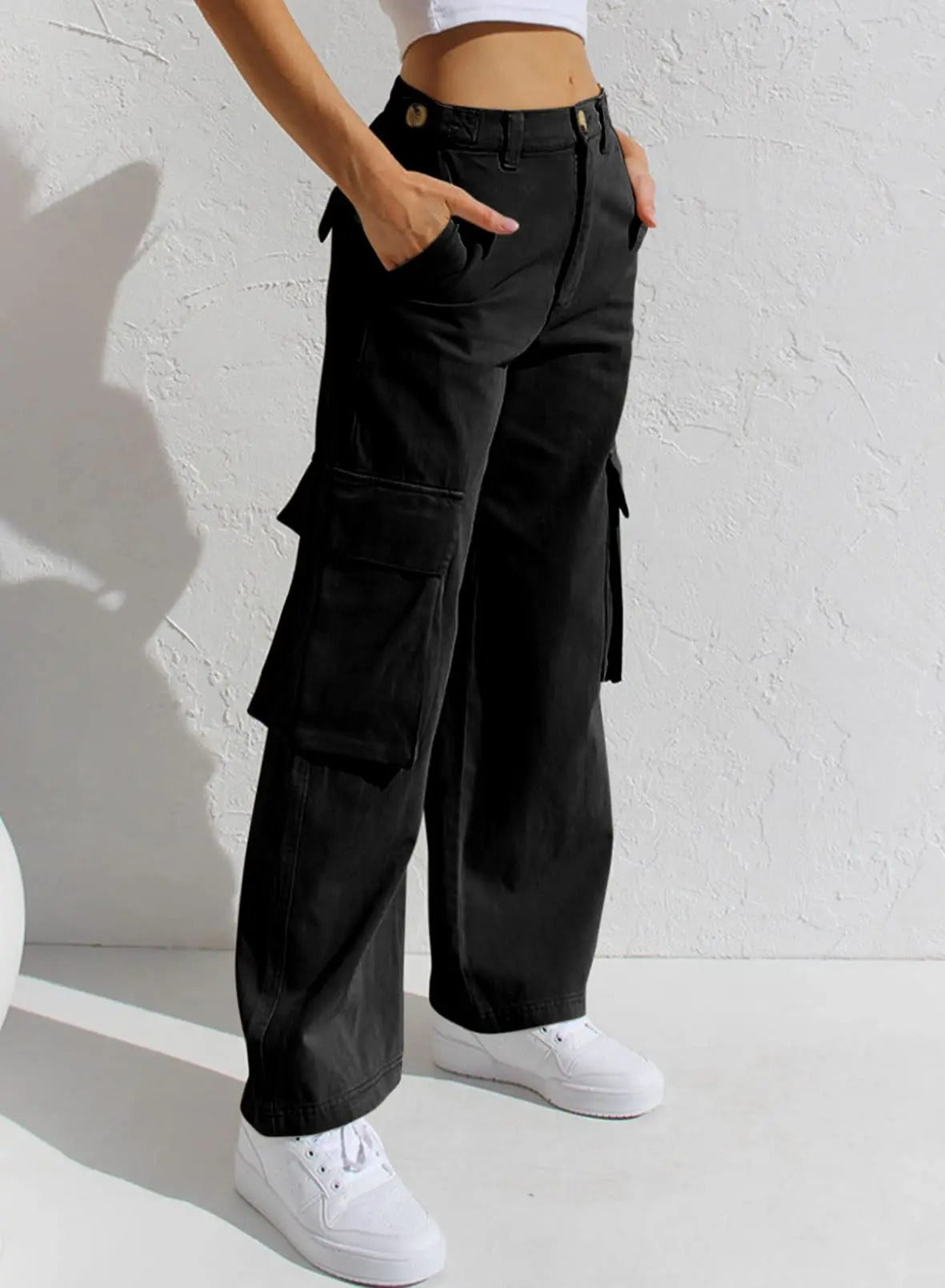 Schwarze Cargo-Hose für Damen, lässig und modern, mit Seitentaschen. Perfekt für Streetwear-Looks. Kombiniert mit weißen Sneakern.