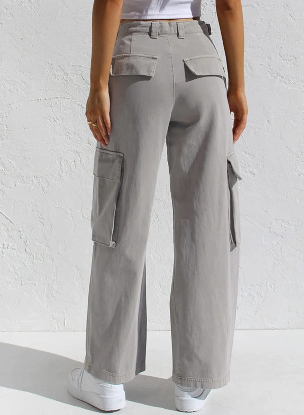 Graue Cargohose Damen, weites Bein, Taschen, lässiger Stil, ideal für Freizeitmode, kombiniert mit weißen Sneakers, trendige Streetwear.