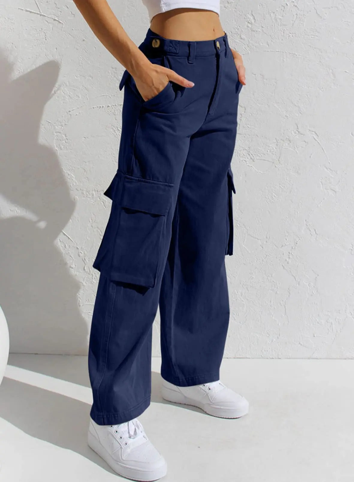 Dunkelblaue Cargohose für Damen, lässiger Stil, mit Seitentaschen, ideal für Freizeitmode. Kombiniert mit weißen Sneakern.