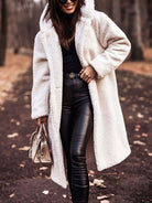 Frau in weißem Teddy-Mantel, schwarze Lederhose, Sonnenbrille, Herbstwald. Modetrend, stilvoll, elegant, Damenmode, Herbstoutfit.