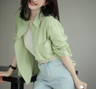 Frau in hellgrüner Bluse und blauer Jeans, lässiger Look, Mode, Damenbekleidung, Freizeitoutfit, stilvoll, modern, trendige Kleidung.