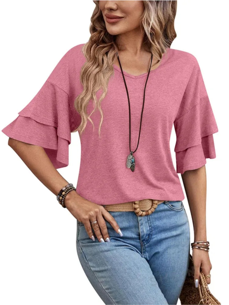 Frau in rosa Rüschenbluse und blauer Jeans, modisches Outfit, lässiger Stil.