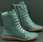 Grüne Damenstiefel aus Leder mit Schnürung und seitlichem Reißverschluss, modisch und bequem, ideal für Herbst und Winter.