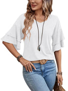 Frau in weißem Rüschen-Top und blauer Jeans, modisches Outfit, lässiger Stil.