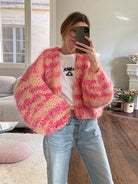 Frau im gemütlichen, handgestrickten rosa Pullover, Selfie im Wohnzimmer. Modetrend, Strickmode, lässiger Stil, Herbstmode, Damenbekleidung.
