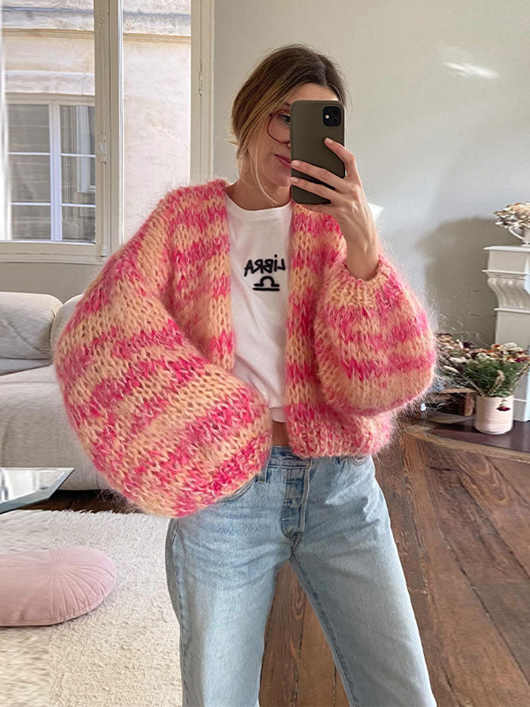 Frau im gemütlichen, handgestrickten rosa Pullover, Selfie im Wohnzimmer. Modetrend, Strickmode, lässiger Stil, Herbstmode, Damenbekleidung.