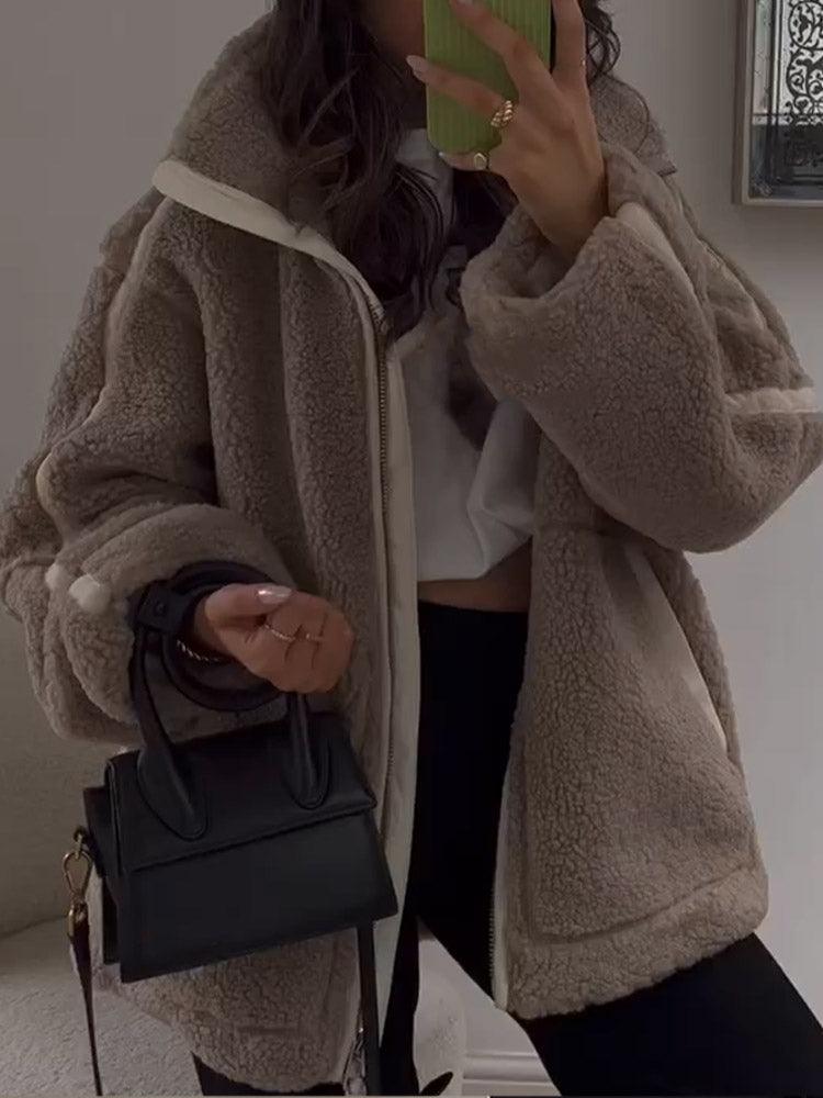 Damen Teddyjacke in Beige, kuschelig und modisch, kombiniert mit schwarzer Mini-Handtasche. Perfekt für Herbst- und Wintermode.