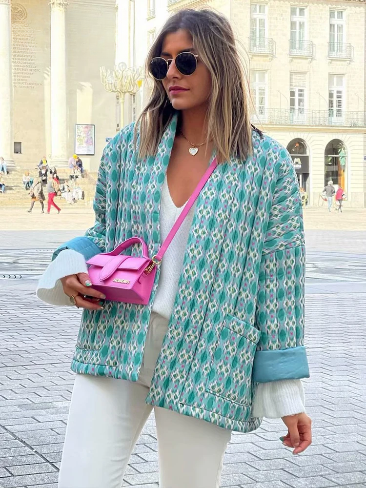 Frau in stilvoller, gemusterter Jacke und weißem Outfit, trägt eine pinke Designer-Handtasche. Perfekt für Mode, Streetstyle, urbane Trends.