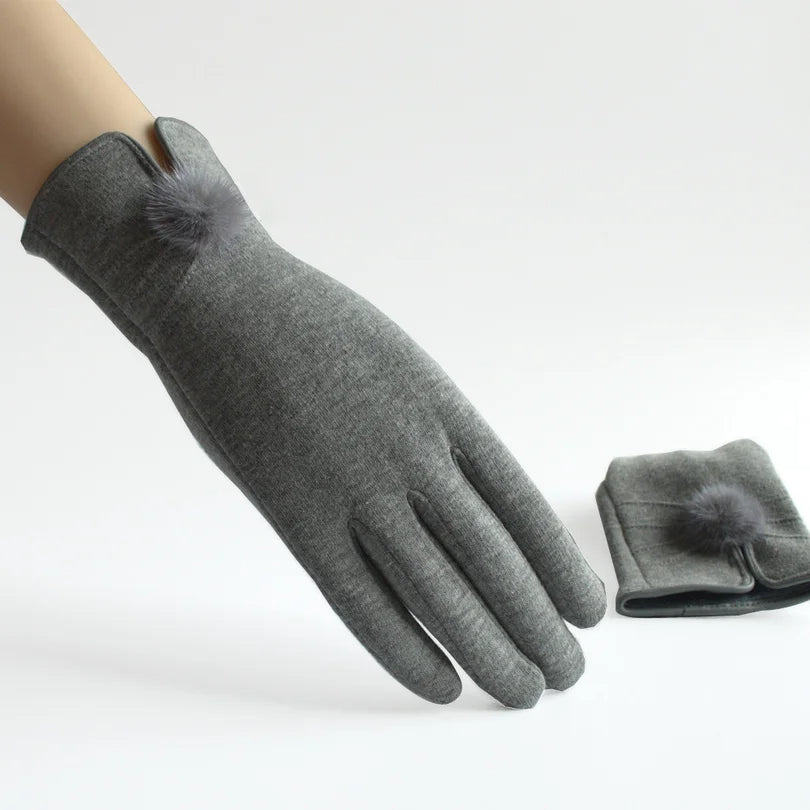 Graue Damenhandschuhe aus weichem Stoff mit dekorativem Pompon, ideal für Herbst und Winter. Elegantes Design, warm und stilvoll.