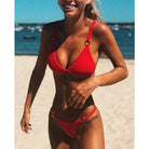 Rotes Bikini-Set am Strand, ideal für Sommermode und Strandurlaub. Zweiteiliger Badeanzug, trendige Bademode, perfekt für sonnige Tage.