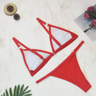 Rotes Bikini-Set auf Marmorhintergrund, zweiteilig, modisch, ideal für Sommer und Strand, Damen-Bademode, trendiges Design, stilvoll.